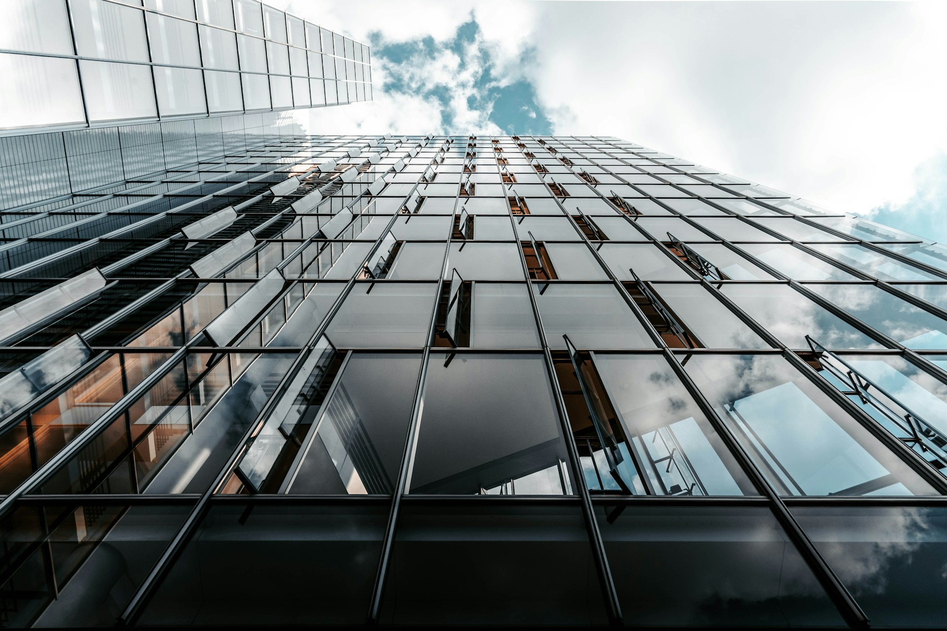 looking up view of a tall building with glass windows