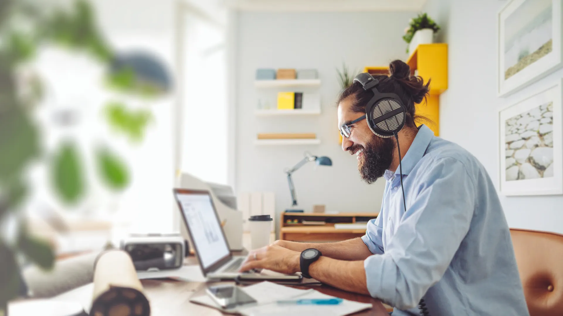 a man wearing headphones and using a laptop a man wearing headphones and using a laptop