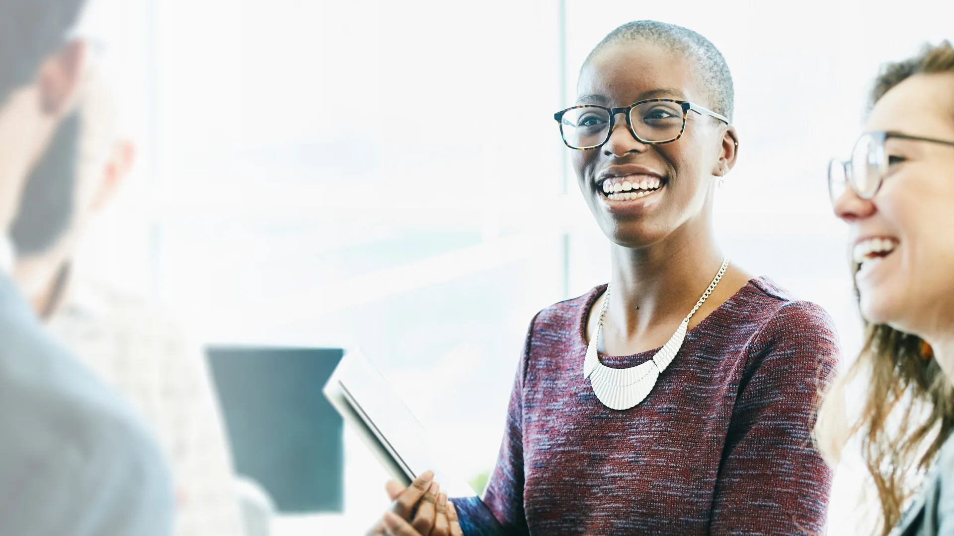 a woman smiling with glasses and a book a woman smiling with glasses and a book