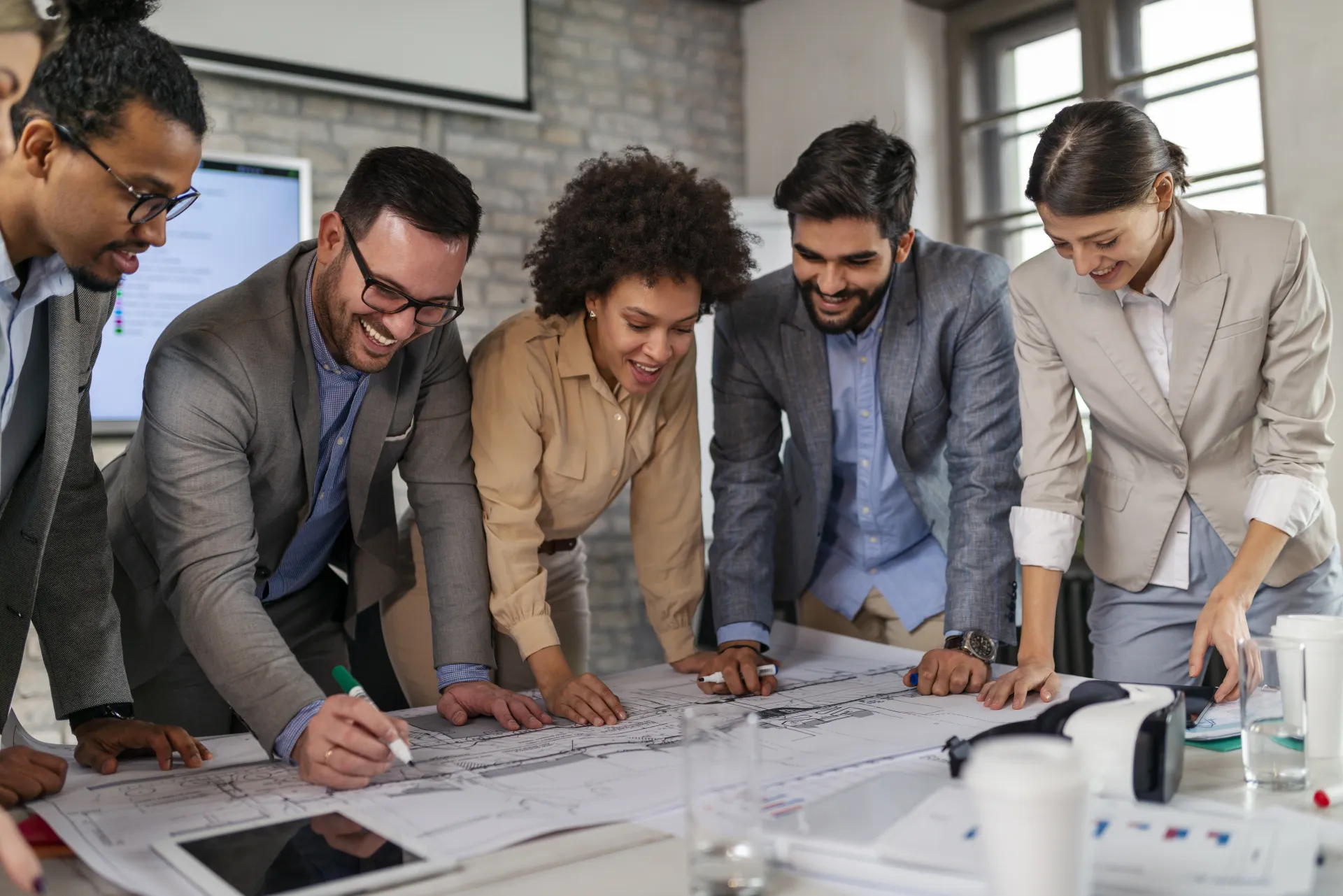 a group of people looking at a blueprint a group of people looking at a blueprint
