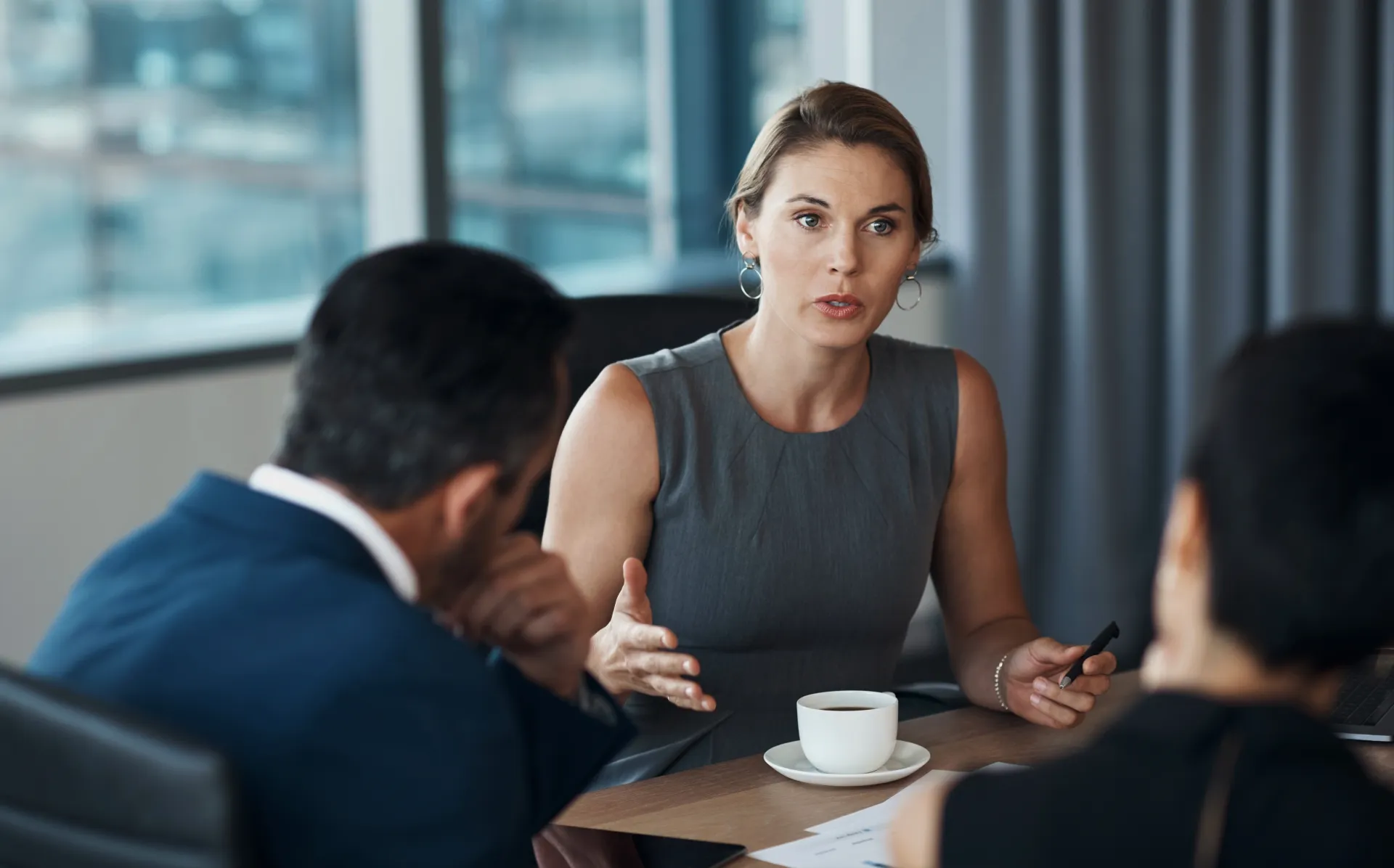 a woman in a grey dress talking to a man a woman in a grey dress talking to a man