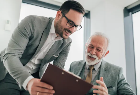 a man looking at a clipboard with another man smiling