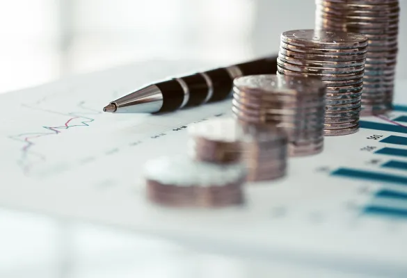 ein Kugelschreiber und ein Stapel Münzen