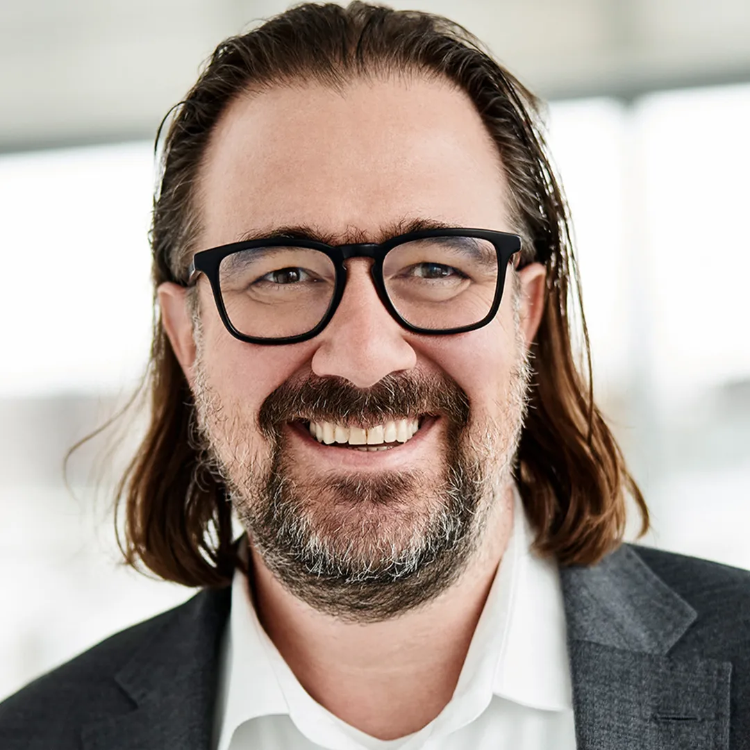 a man with long hair and beard wearing glasses