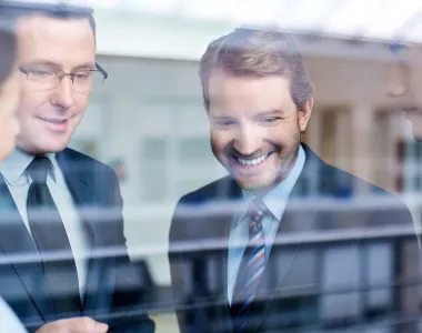 Eine Gruppe von Männern, die auf eine Glaswand schauen